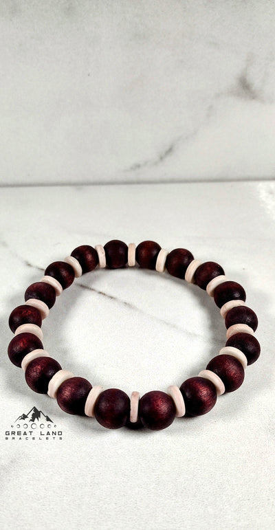 Handmade wooden bracelet featuring dark red and white beads, perfect for casual or bohemian style.